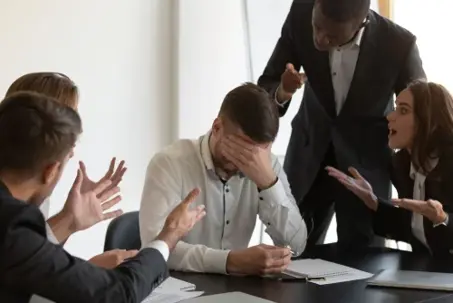 Frustrated employee cover face with hand feels unhappy having serious problems suffers from hostile co-workers, feels guilty, unfair attitude, harassment, stress, discrimination at workplace concept