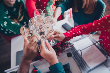 Photo of nice young people team employees drinking champagne circle enjoy cozy christmas decoration interior office indoors corporate party