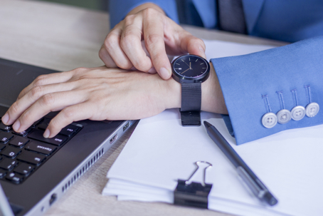 the keyboard and watching at his wristwatch. Time is up. Concept of Time Management, Work Life Balance and Business Control.